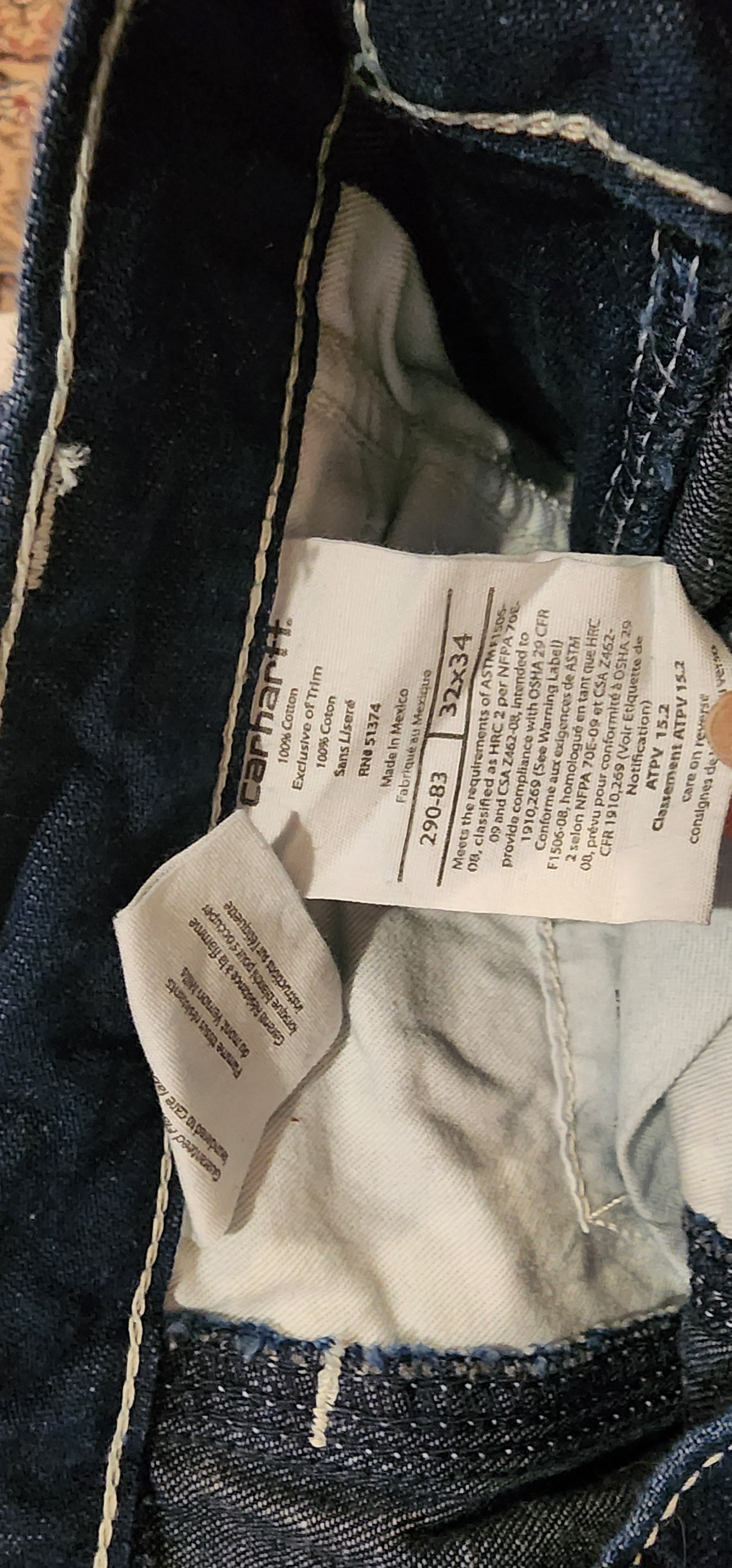 Close-up of a Carhartt label on a denim garment with visible text.